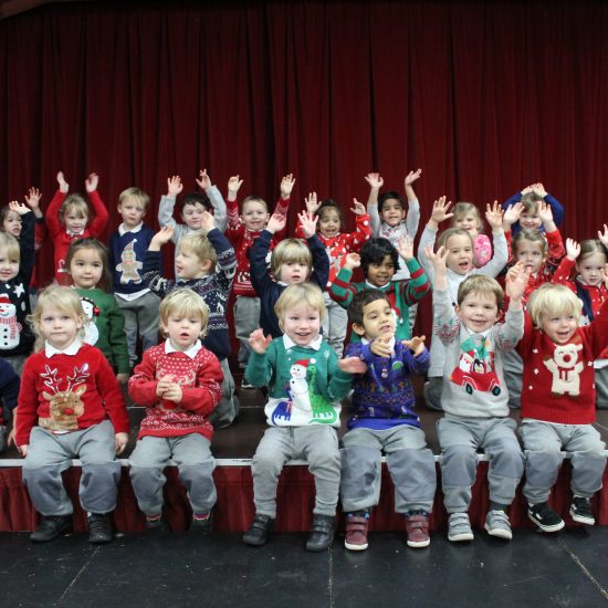 big group of young children wearing Christmas jumpers