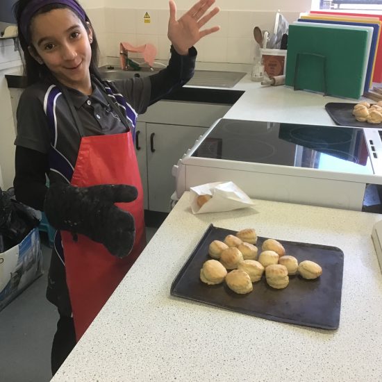 Student with their finished tray of baked scones