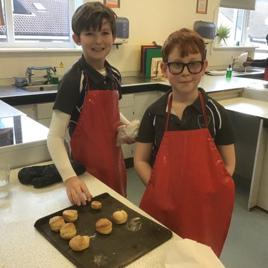 2 students with their scones that have finished baking