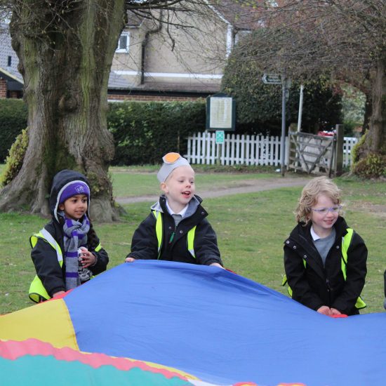 Students holding onto the parachute