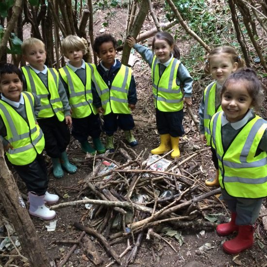 children from a private nursery in Surrey with a pile of logs