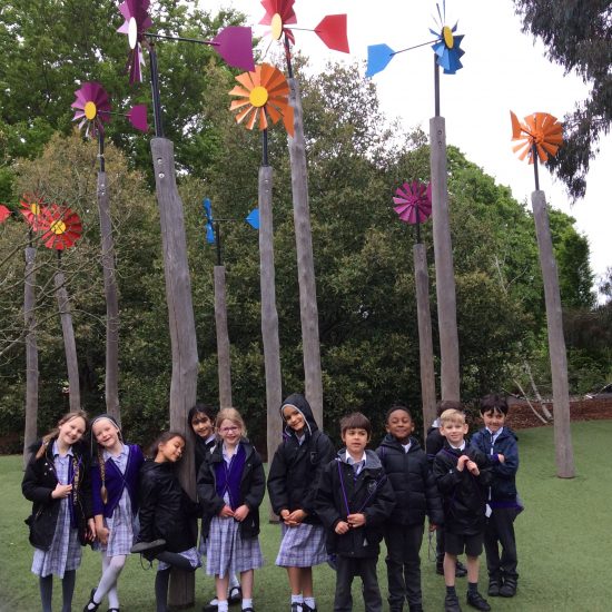 children standing next to tree fans