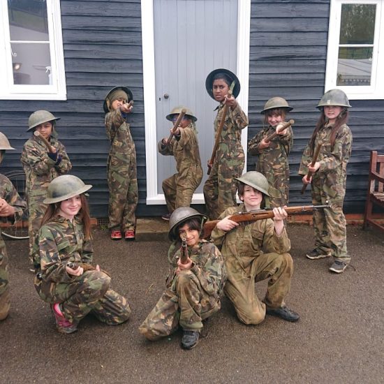children in army uniform pointing