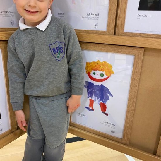 a child standing next to a painting