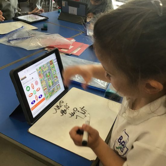 a girl practicing her handwriting with a tablet