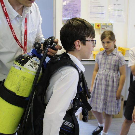 a boy from a prep school in Surrey wearing a underwater oxygen tank