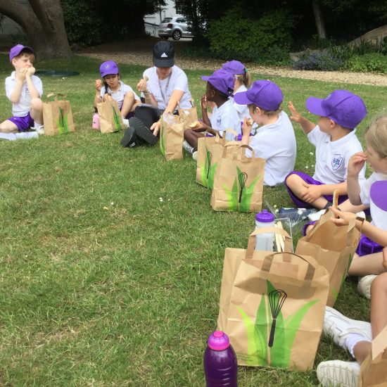 Children eating lunch outside with their lunch bags