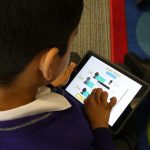 a boy using an ipad at a private school in surrey