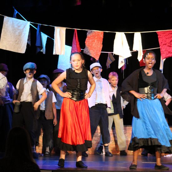 Children dancing and singing for the Oliver! Jr production