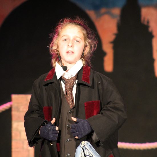 A child acting at the Oliver! Jr production