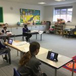 Children talking through an iPad with teachers