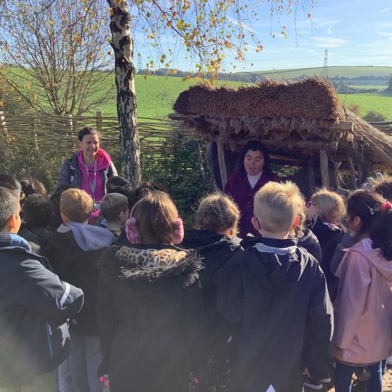 A guide talks to students about Stone Age Britain