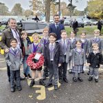 children from a prep school in Surrey holding a remembrance wreath