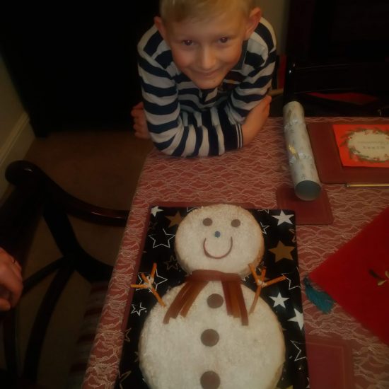 A child from a prep school in Surrey with his snowman cake