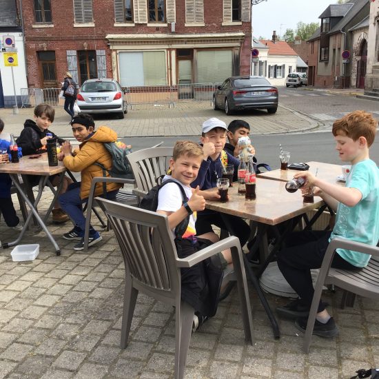 Students having a snack and a soft drink at tables