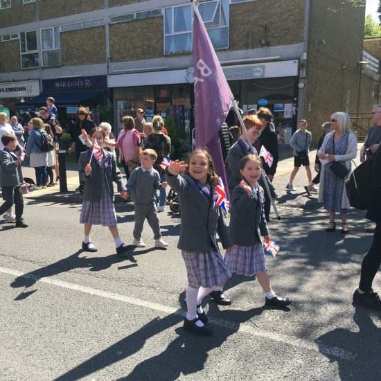 Students waving as the parade moves