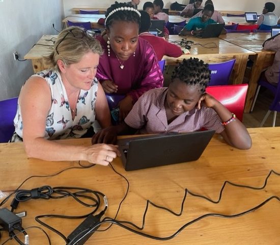 Students learning to use a laptop