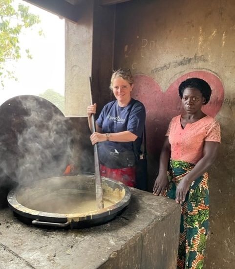 Mrs. Miles stirring a very large pot filled with food