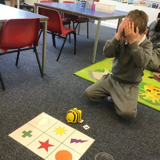student doing an activity with a bee robot