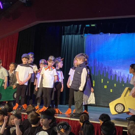 students on stage dressed as penguins and cars
