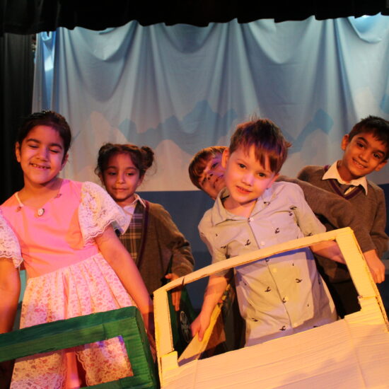 students in a play dressed as cars