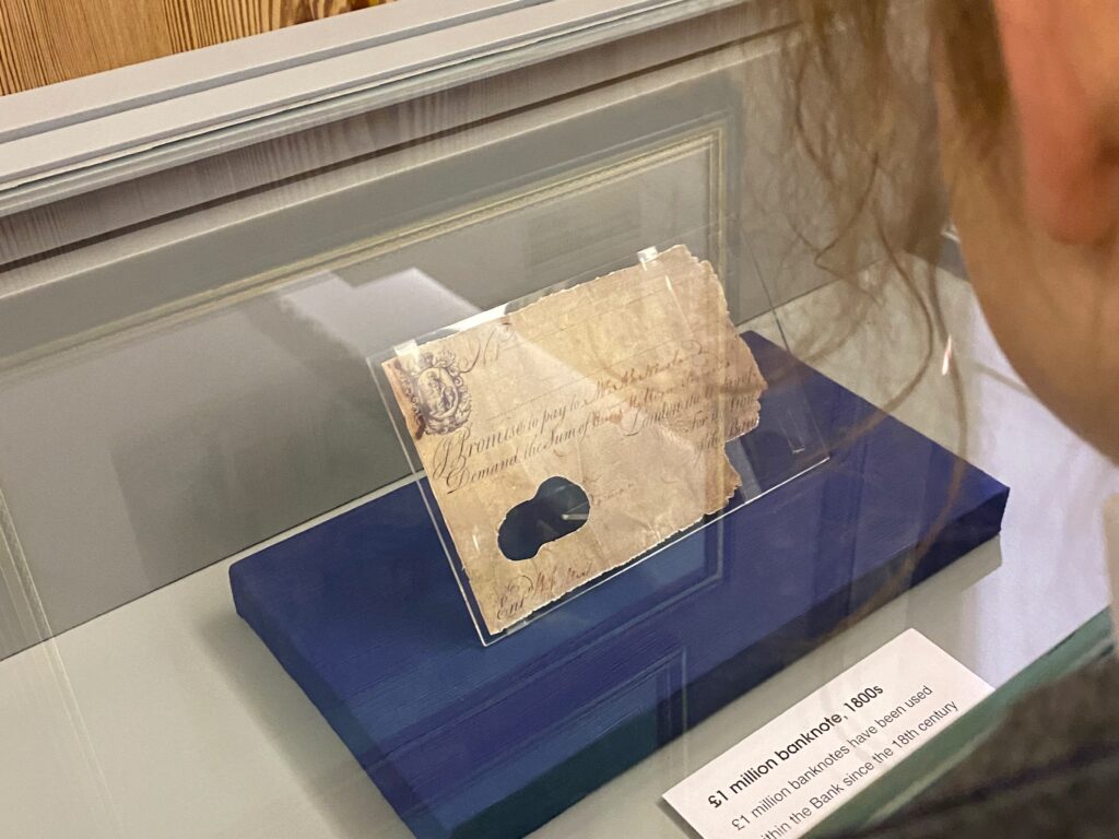 A pupil looking at a £1m banknote from the 1800s on display in a glass case at the Bank of England museum